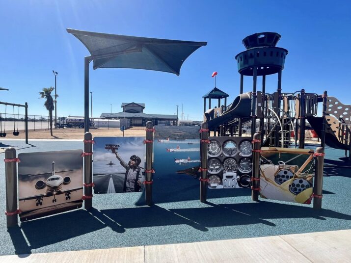 Airport themed playground equipment with dark green shade structures.