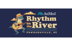A stylized event graphic showing a spotted blue frog wearing an orange hat and playing an acoustic guitar. Next to the frog is the event title “AnMed Rhythm on the River” with wavy lines suggesting water, and the location “Powdersville, SC.” The background is dark navy with decorative clouds and the AnMed logo above the title.