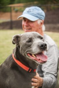 A longtime volunteer spending time outside with a dog named Bryan.